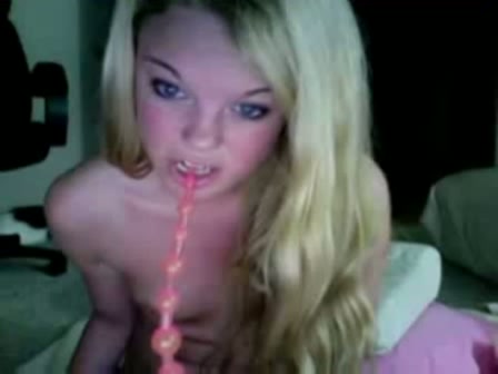 Het meisje stopt een toy in haar anus en pist een glas vol voor de webcam