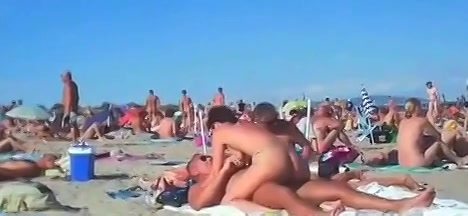 zuigende en naaiende koppels worden gefilmd op het spiernaakt strand 